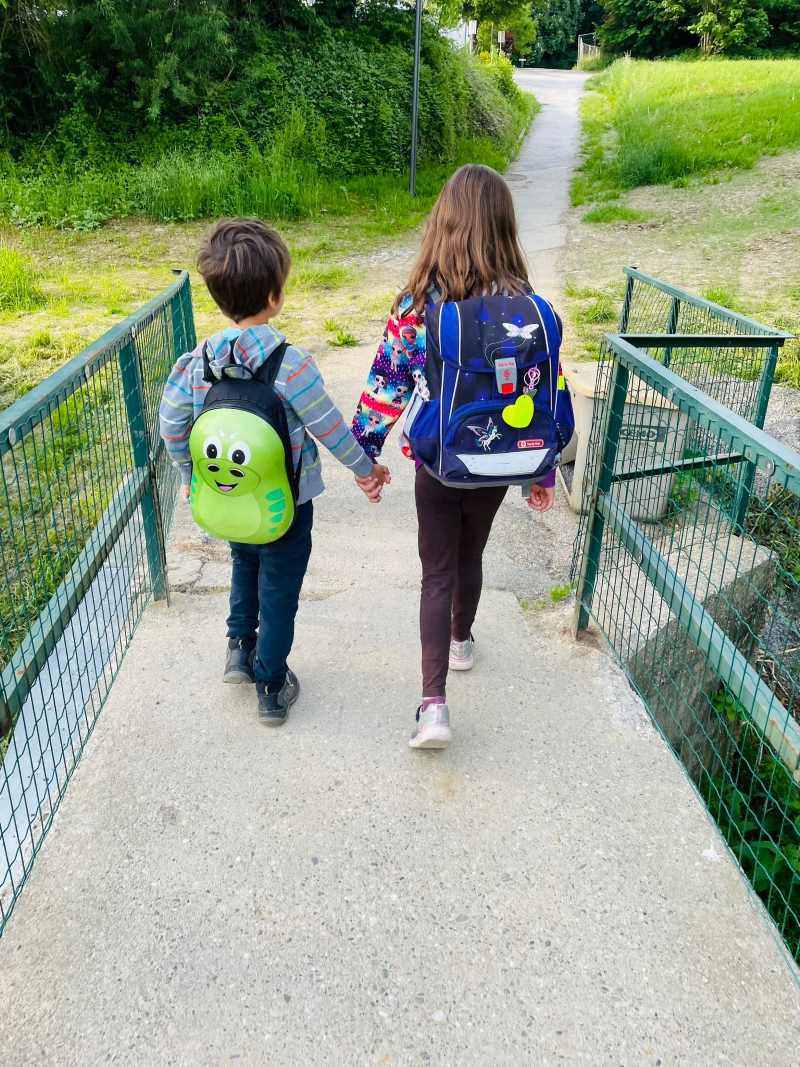 Zu sehen sind: zwei Kinder auf dem Schulweg