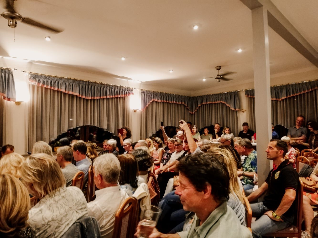 Zu sehen sind: Menschengruppe bei einem Konzert beim Wirt